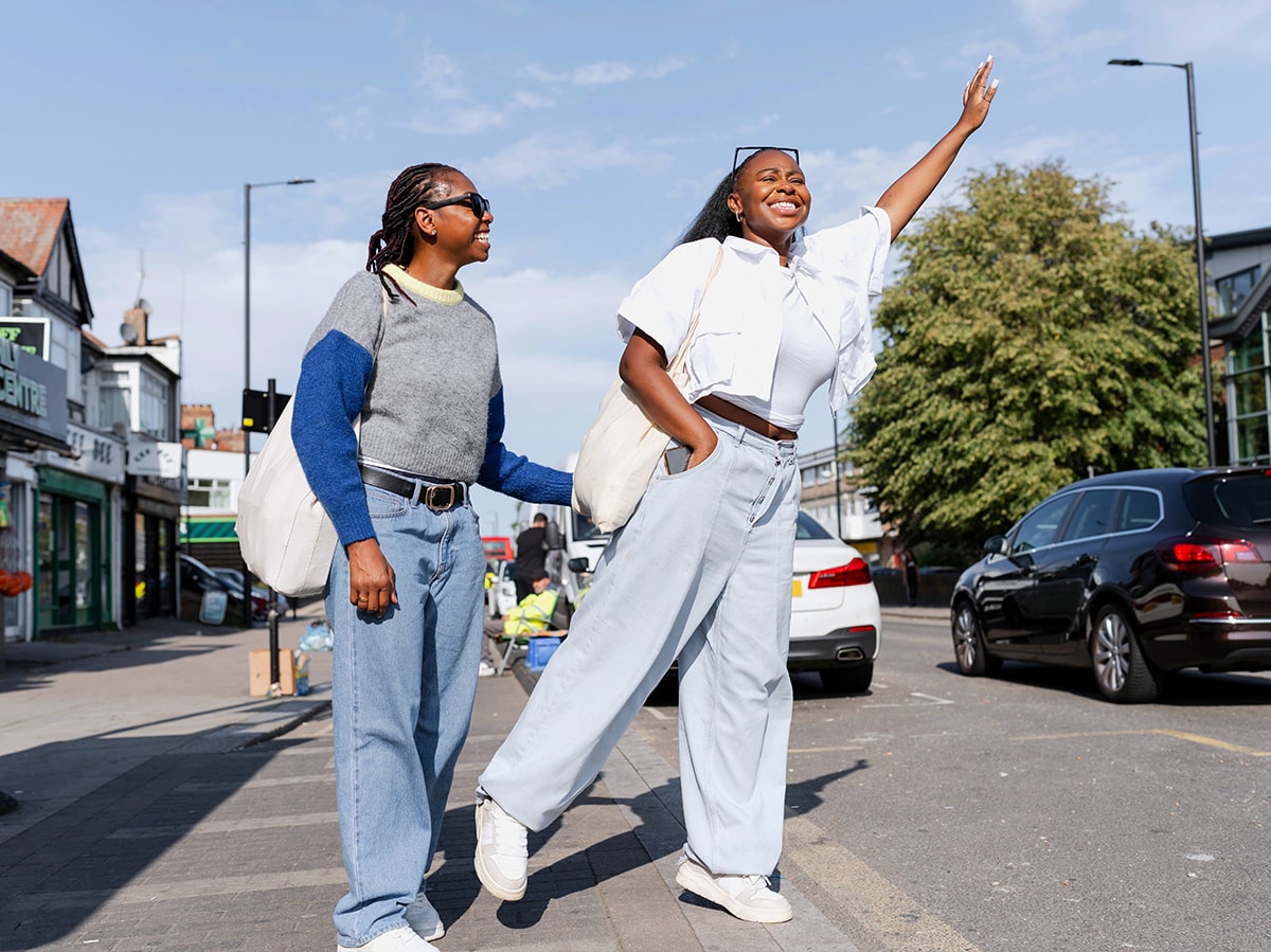 Happy passengers waiting at a city bus stop – Mattersoft LIVEtsp Transit Signal Priority (TSP) software improves public transport schedule adherence by requesting green lights intelligently, reducing delays, cutting early arrivals, and ensuring reliable, on-time services.
